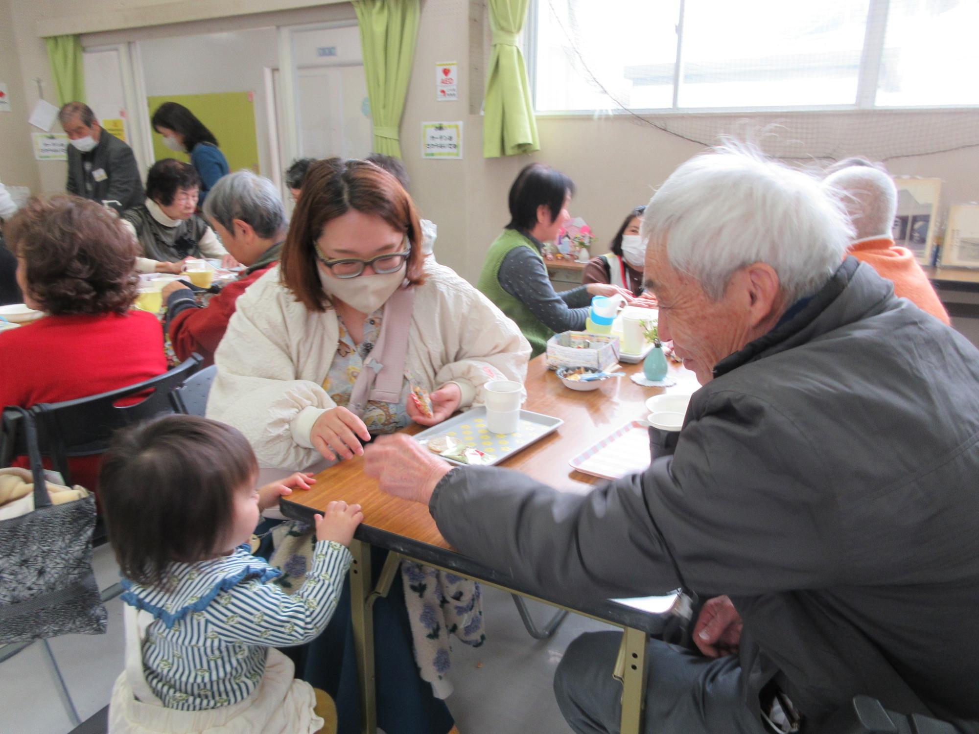 小さいお子さんに癒される地域の方の様子の写真