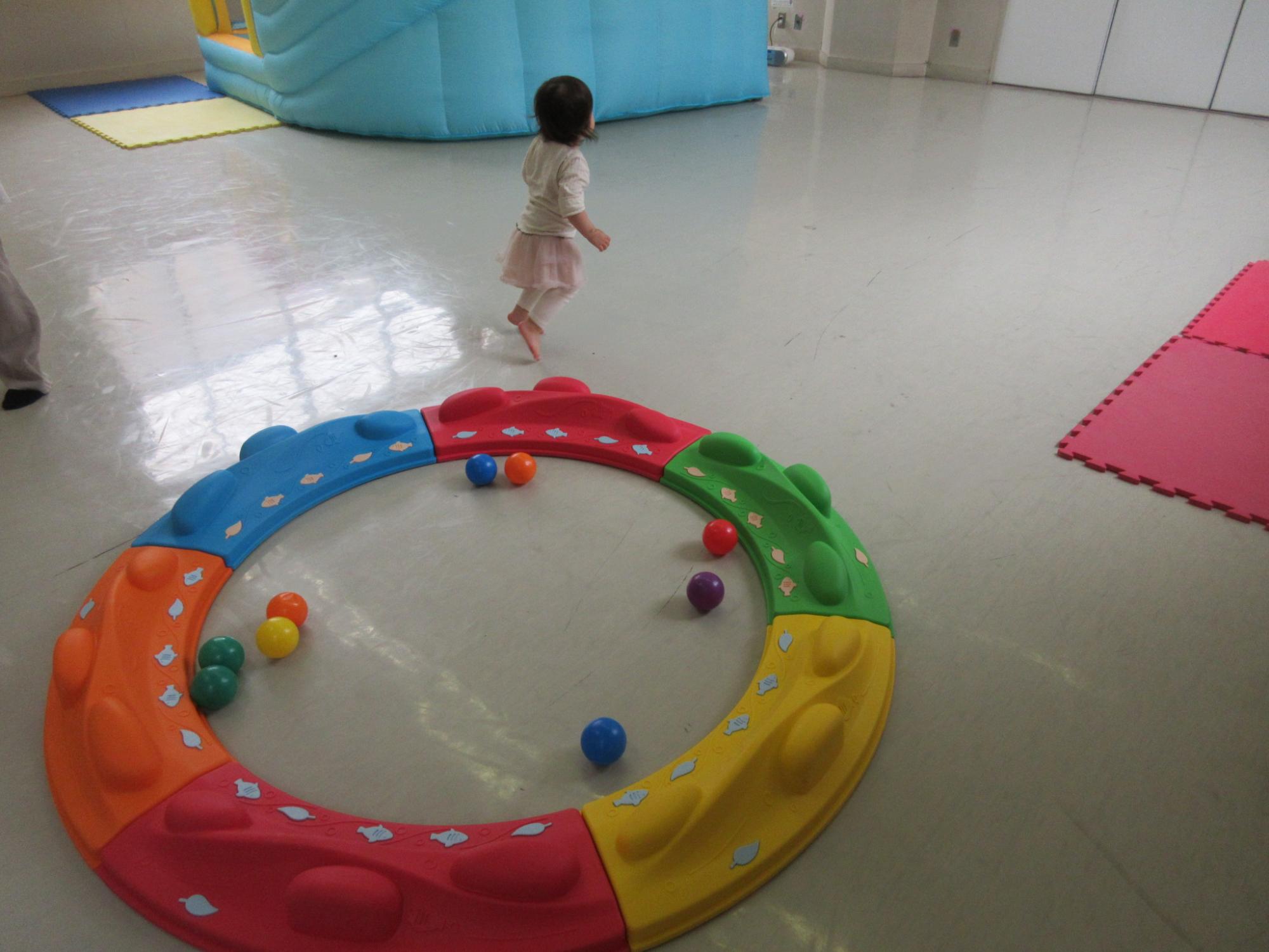バランスサークルにボールを入れる幼児の様子の写真