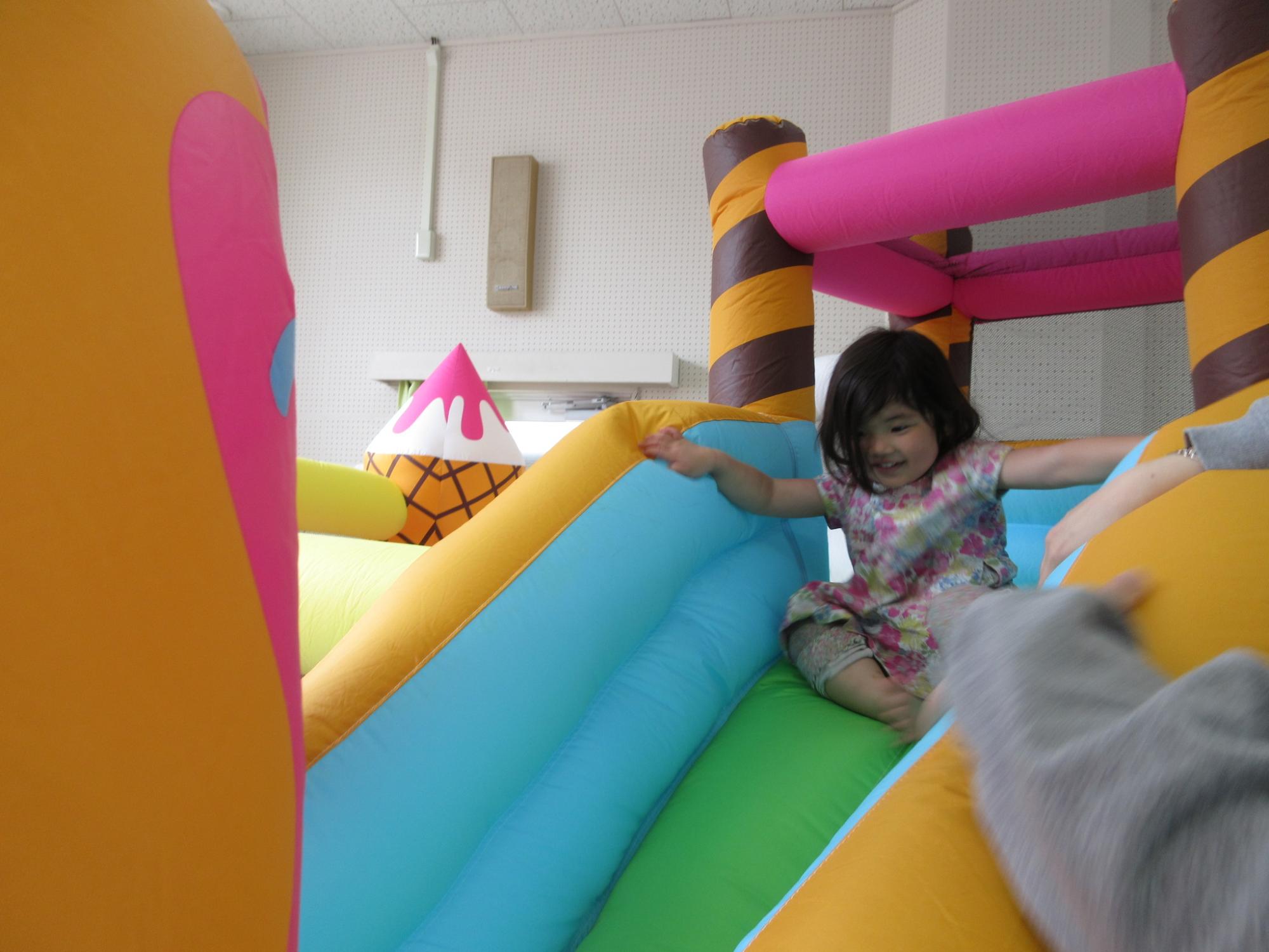 エアバルーンを何度も楽しそうに滑る幼児の様子の写真