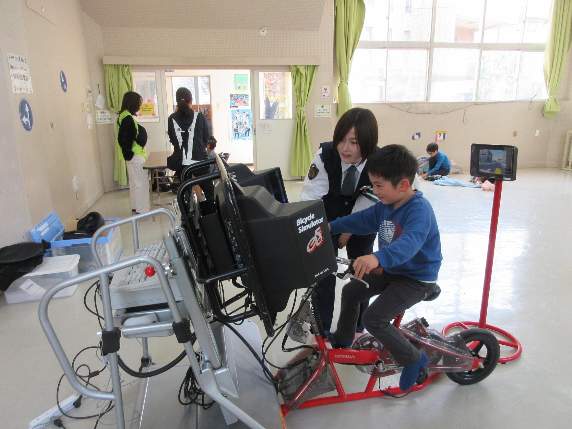 自転車シミュレーターで安全な自転車運転を習っているこどもの様子の写真