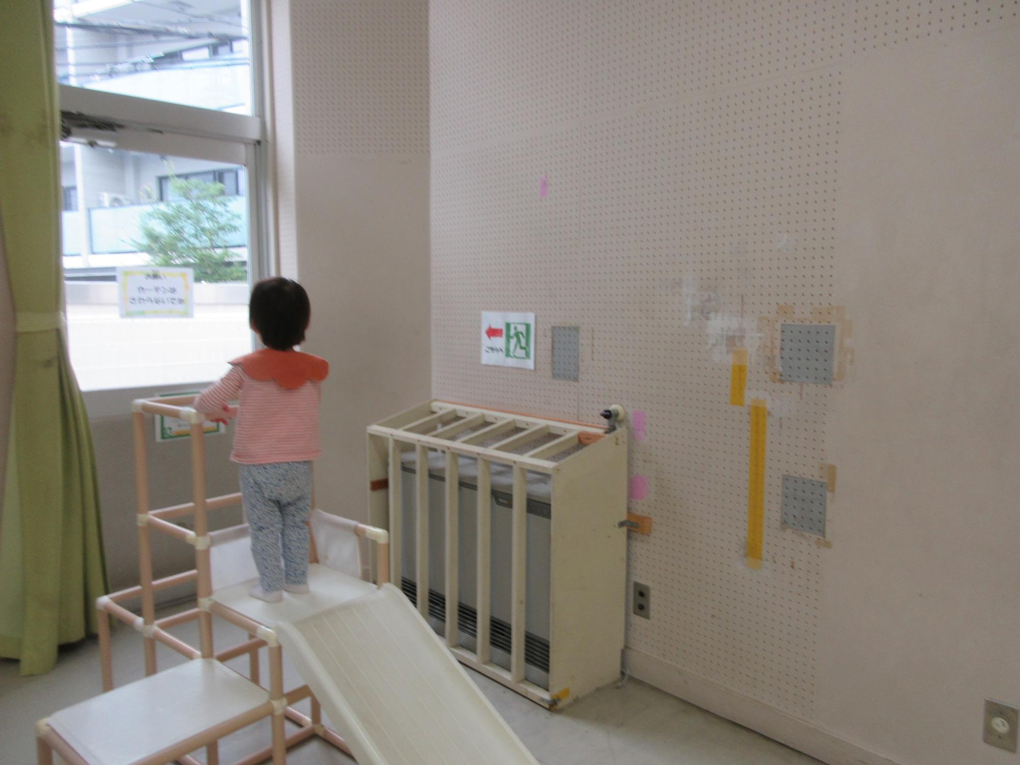 滑り台から外をながめている幼児さんの様子の写真