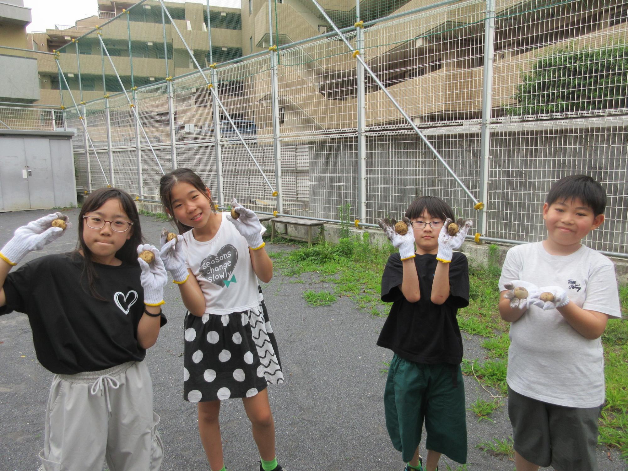 収穫したじゃがいもを持っった子どもたちの集合している写真