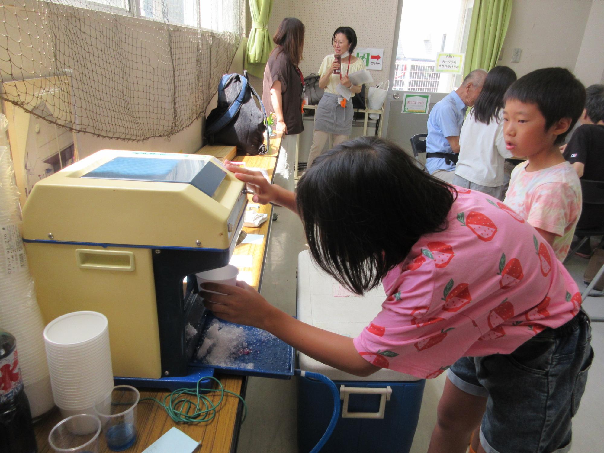 注文のかき氷を作る中学生の様子の写真