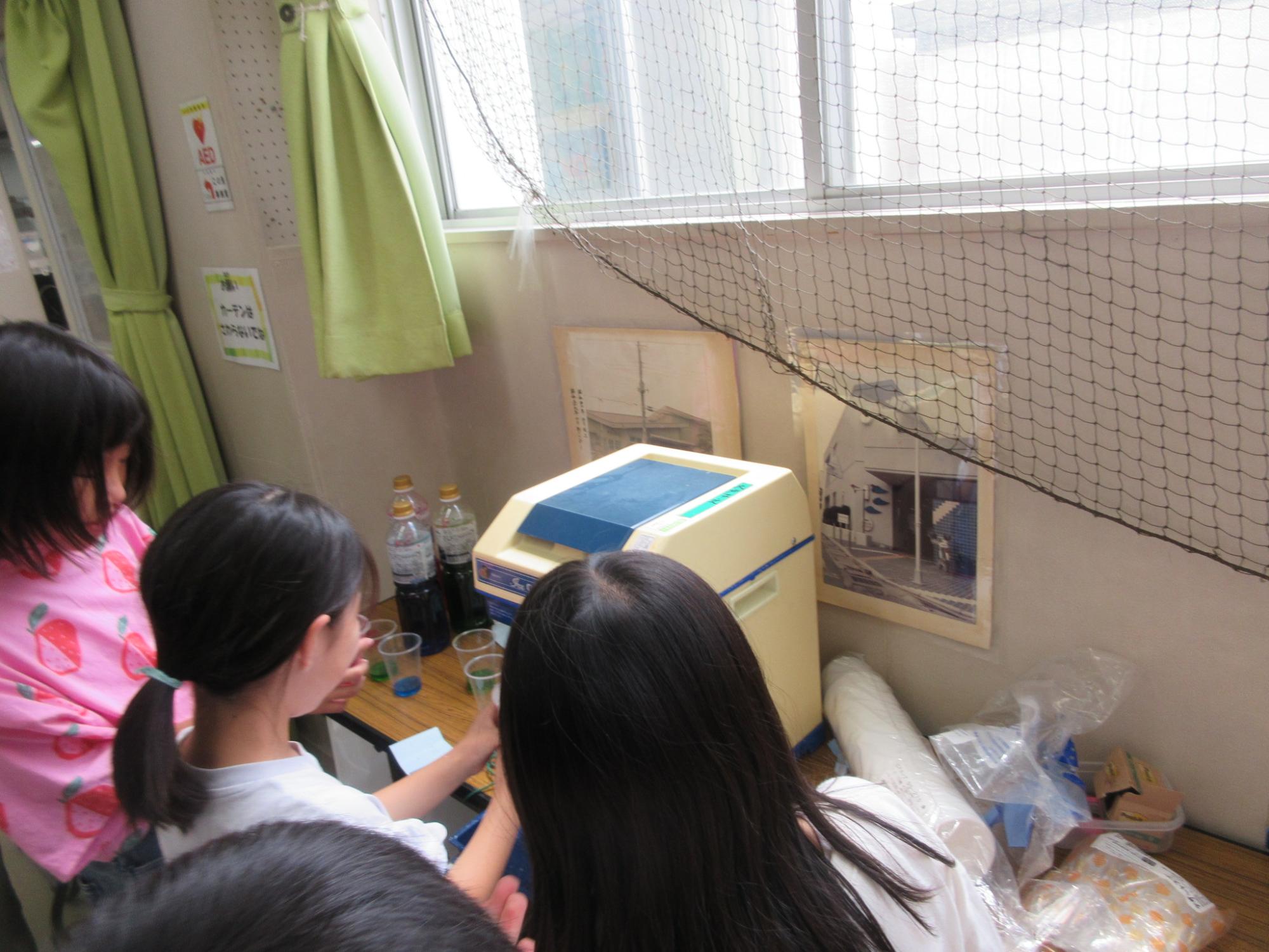 お手伝いがひと段落して自分たちのかき氷を作っている小中学生の様子の写真