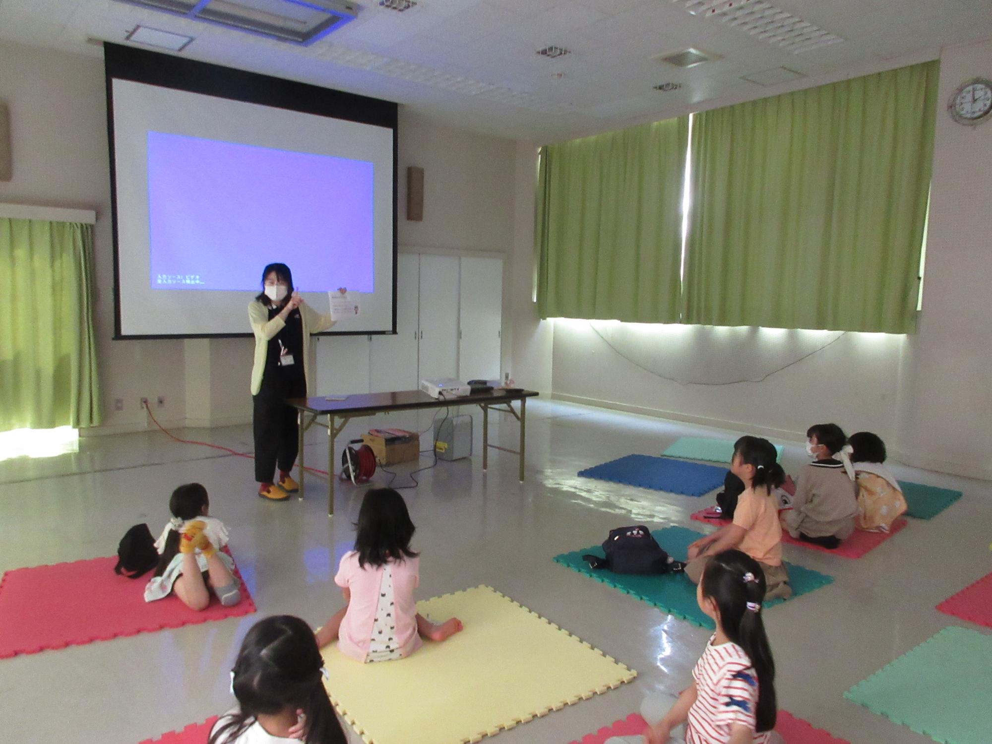 映画を観るときのお約束のお話を聞く子どもたちの様子