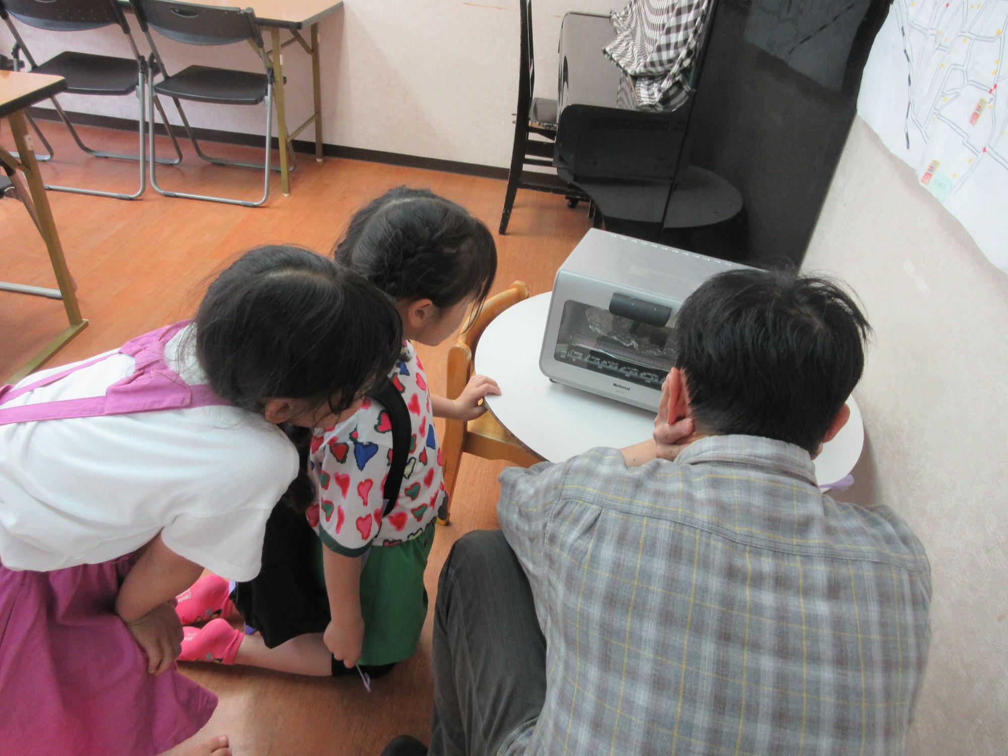 プラバンが焼きあがる様子を見ている子どもたちの様子の写真