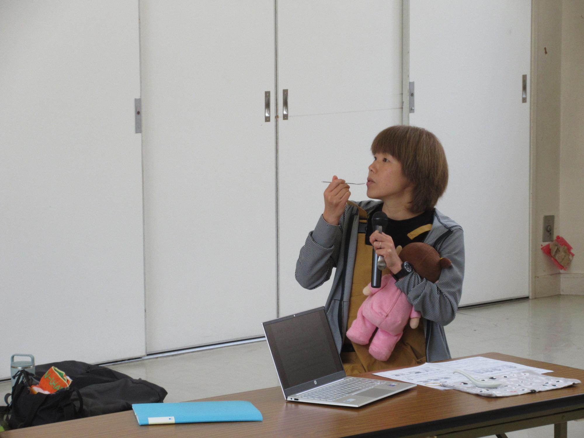 子どもの食事の介助をする際のスプーンの角度について先生がお話している様子の写真