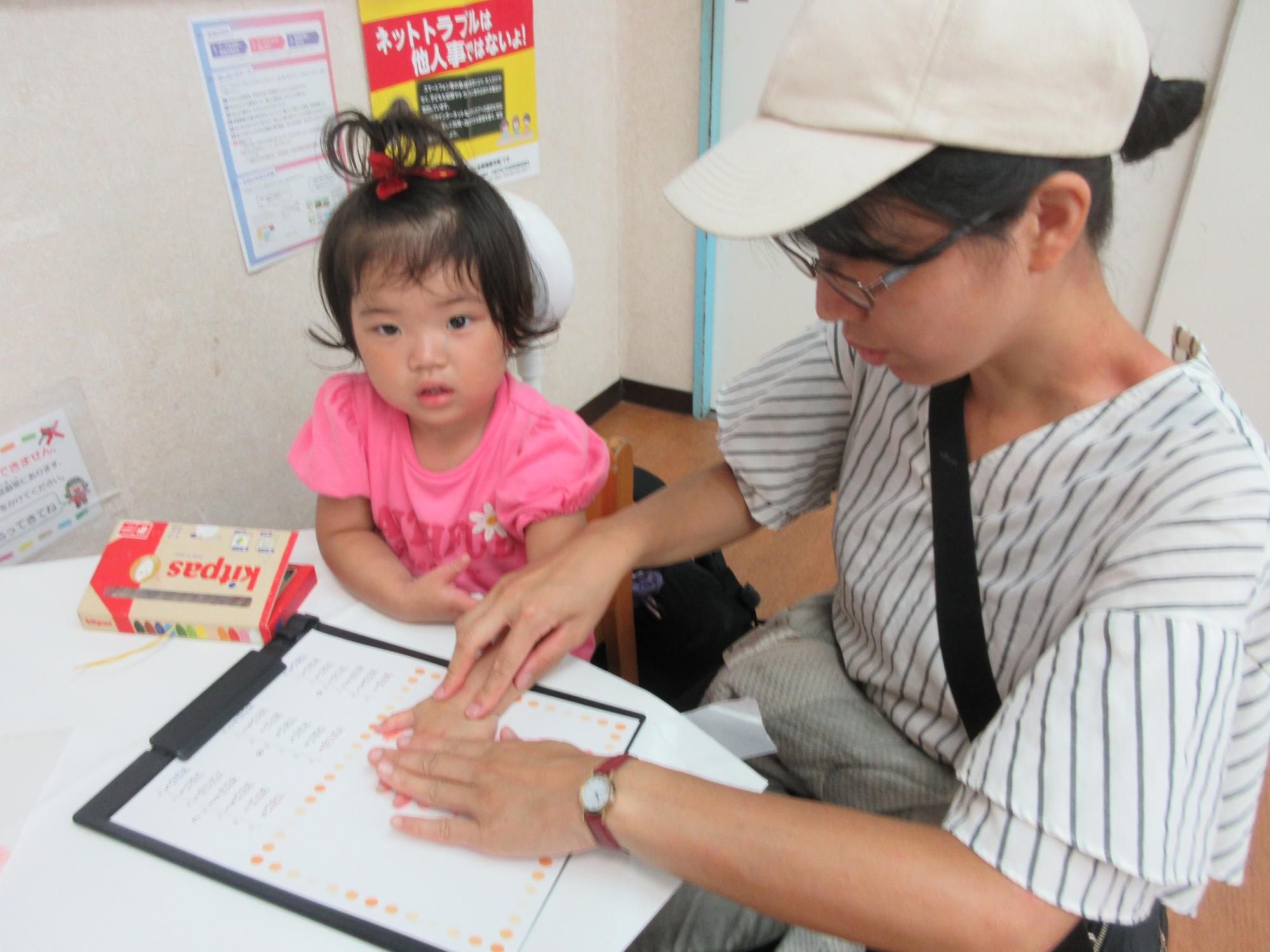 手形を取って、夏のカレンダーを作る幼児親子の様子の写真