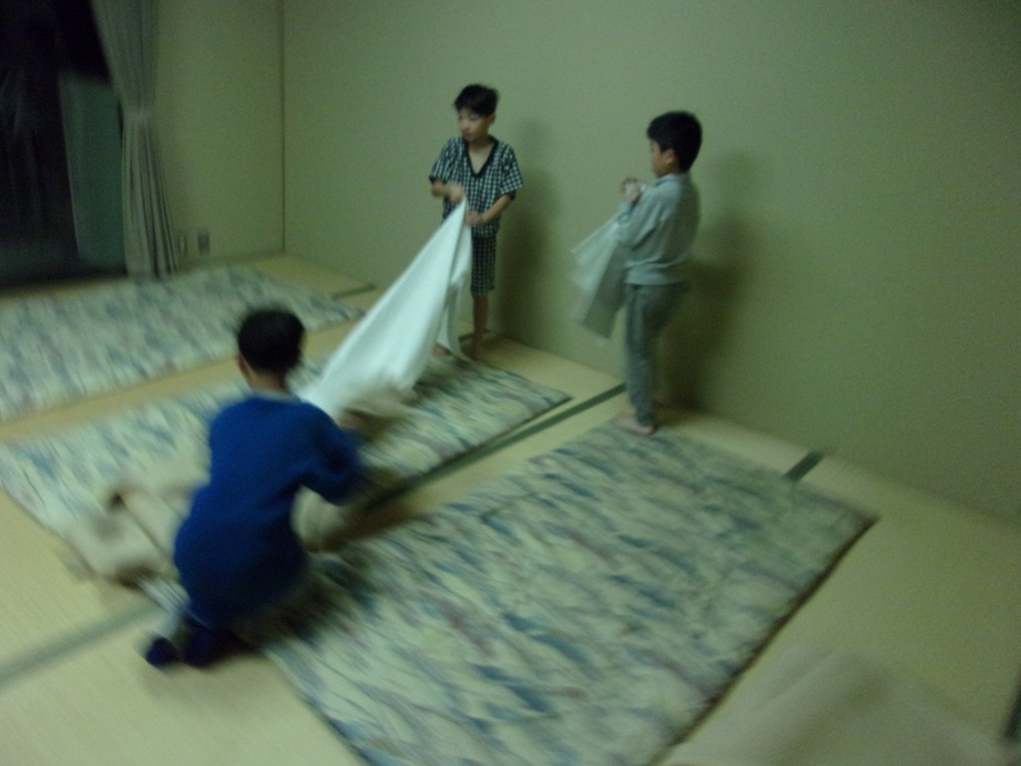 協力して布団を敷いている写真