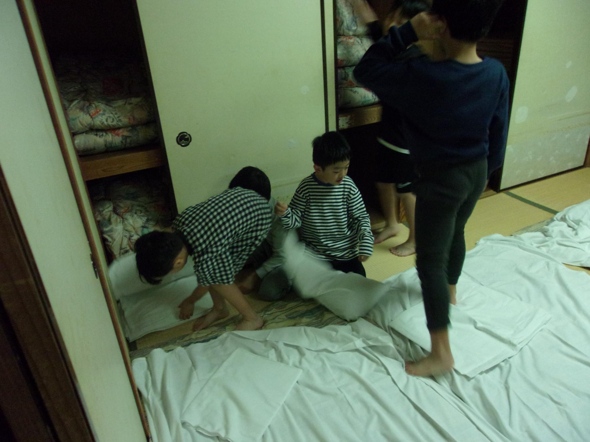 協力して布団を敷いている写真2