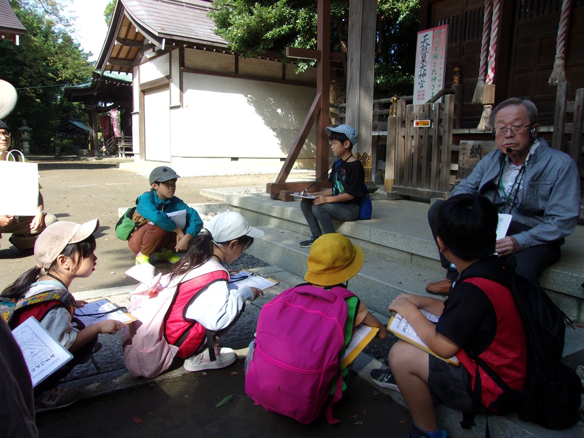 春日神社で雨乞いの竜の伝説の話を聞いている写真