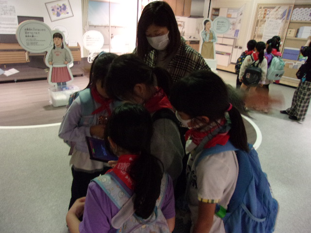 避難所でタブレットを使いクイズに商戦している写真