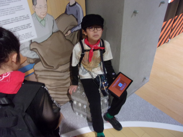 ペットボトル48本でできているイスに座っている写真