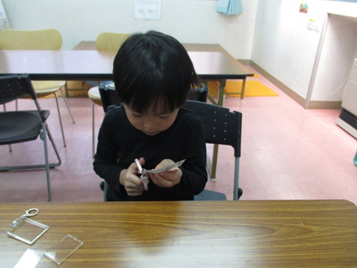 きらきらキーホルダーに入れる絵を切っている写真