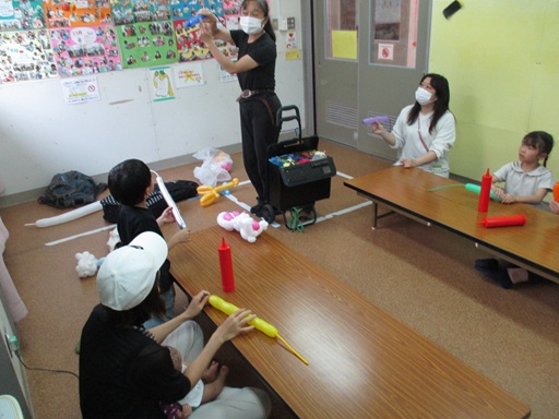 先生にネズミの作り方を教わっている写真