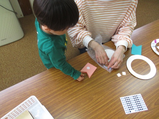 おかあさんがかぶとを折ってくれてるのを見ている写真