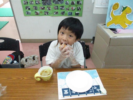 チーズバーガーを大きな口で食べている写真