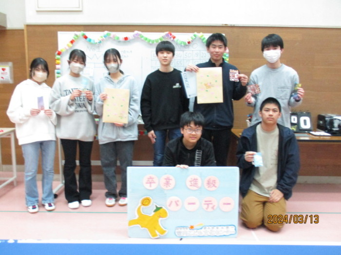 前列に2名後列に6名に子供たちが並び、前列左に座っている男の子が「卒業進級パーティー」と書かれたボードを持っている集合写真