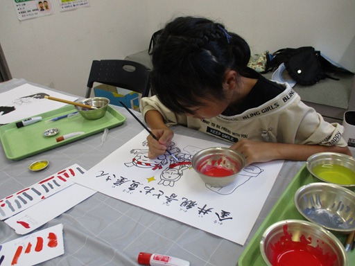 紙芝居に絵の具で色塗りをしている写真