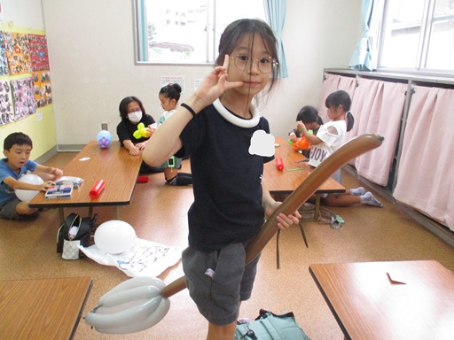 バルーンで作ったほうきにまたがっている写真