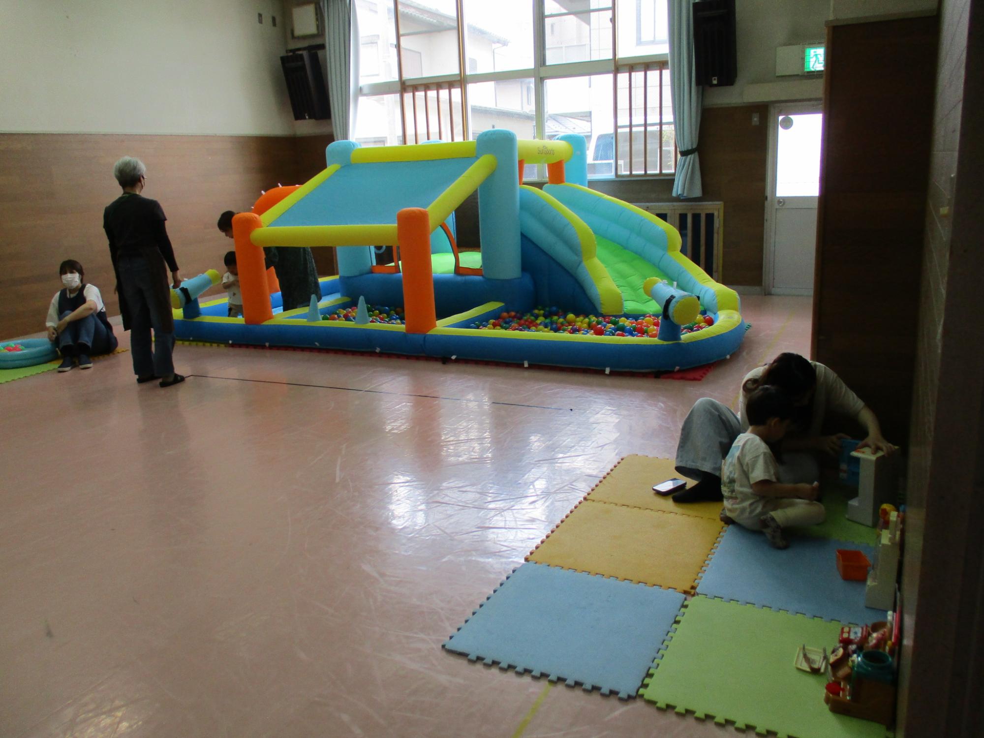 大型遊具のすべり台やボールプールで遊んでいる様子。