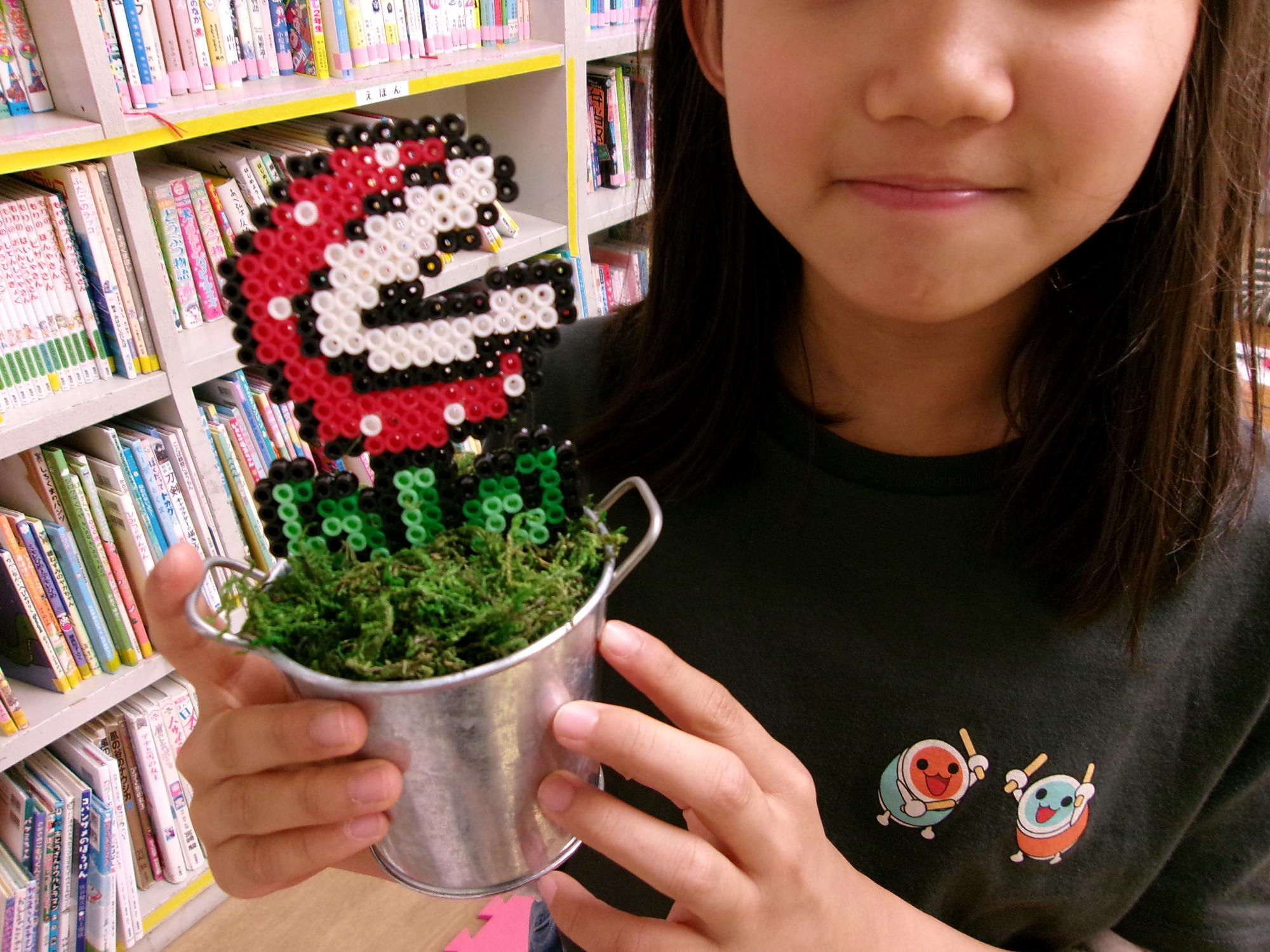 植木鉢に見立てたブリキ缶にアイロンビーズで作ったサボテンを植えた写真