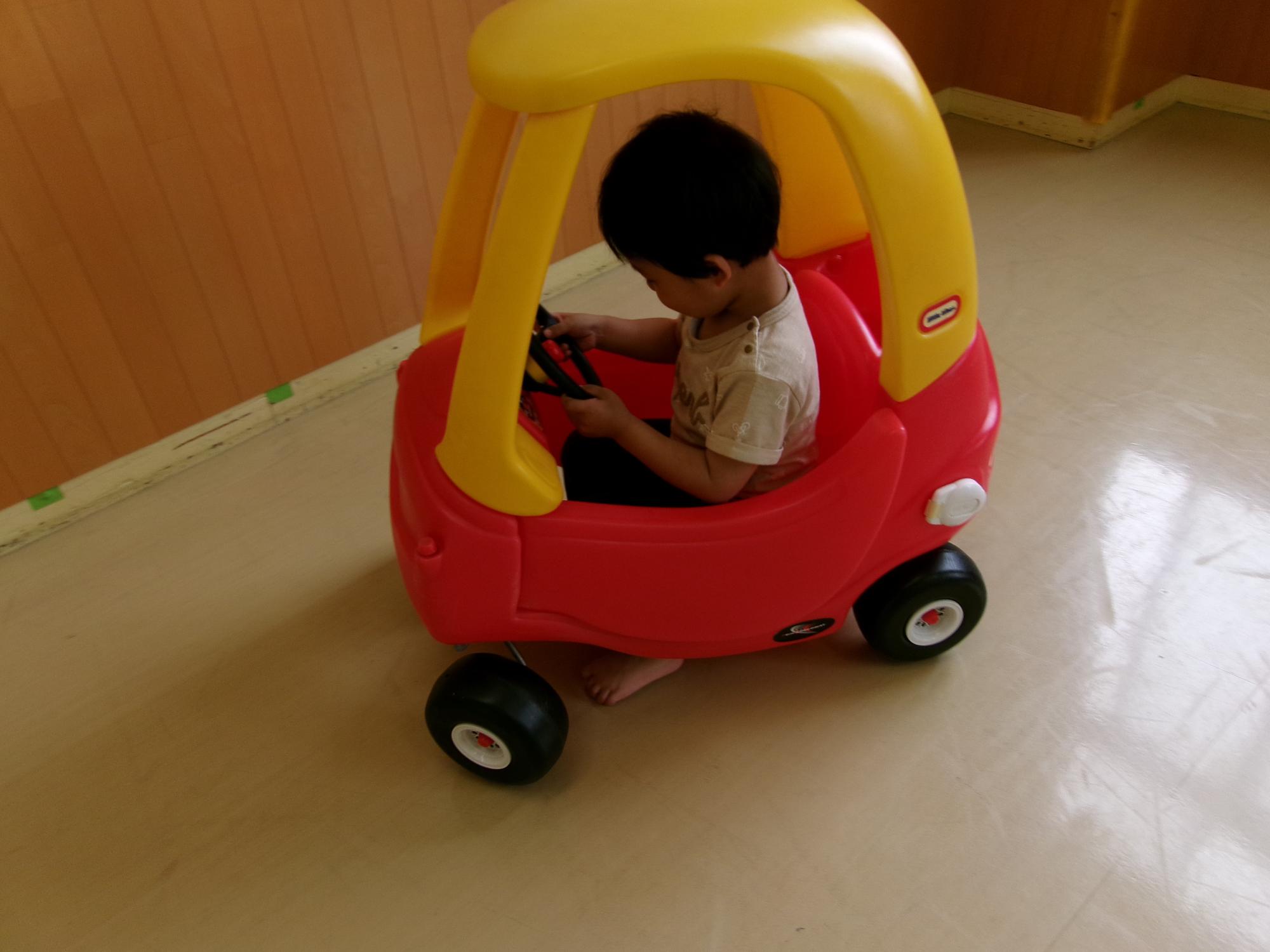 自分の足で進む車に乗ってい楽しく遊んでいる写真