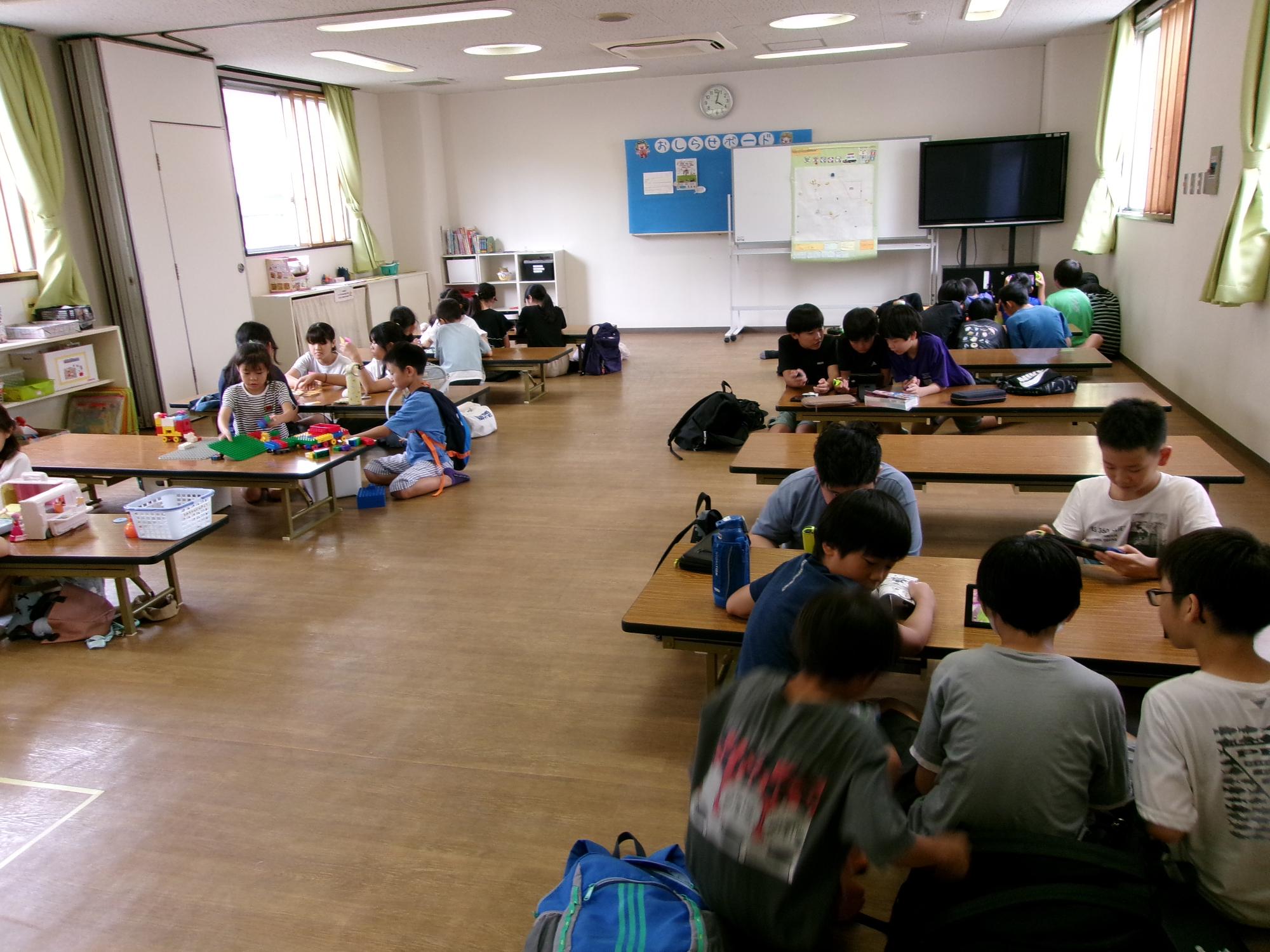子どもたちがゲームやおもちゃで遊んでいる様子の写真
