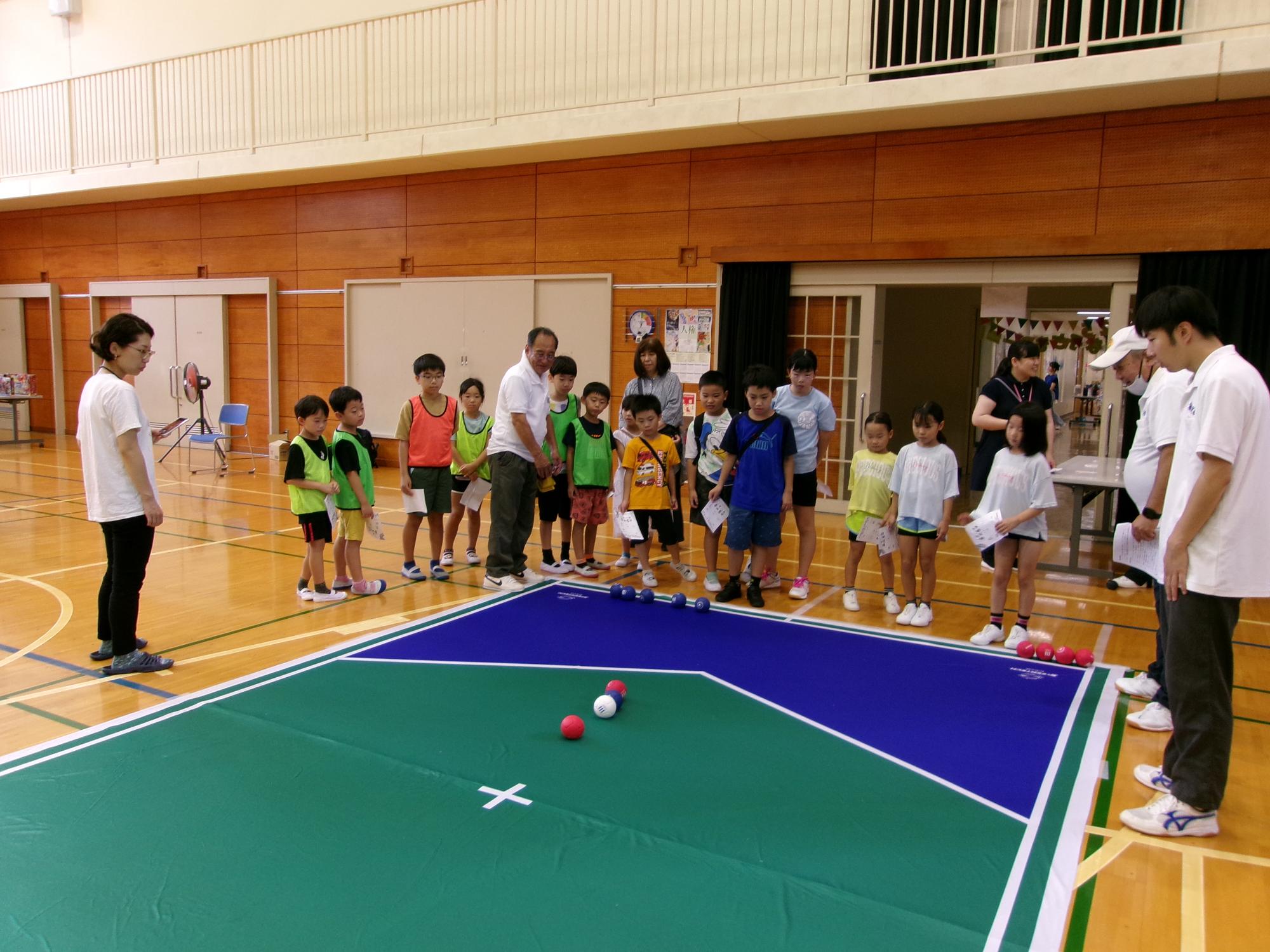 ボッチャのブースで説明を受けている子どもたちの写真