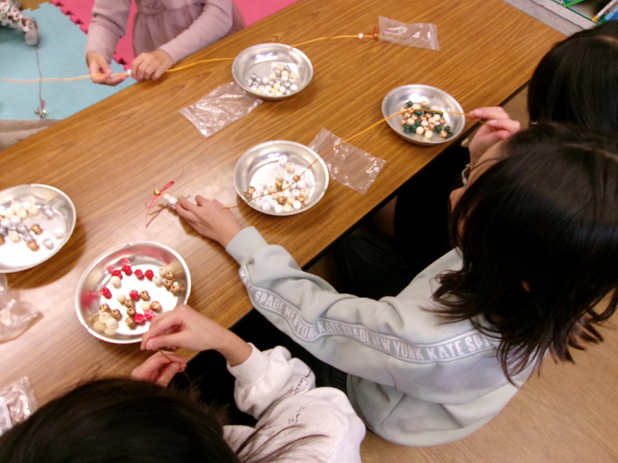 子どもたちがウッドビーズをどの順番にしようか考えている写真