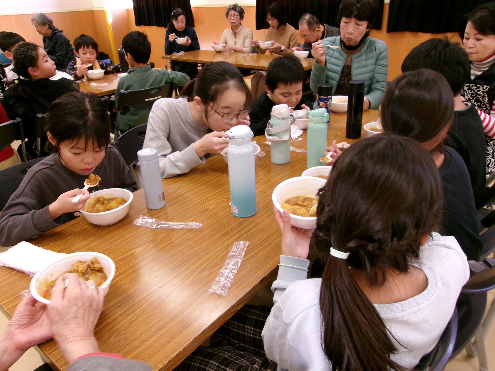 掃除後、みんなでカレーを食べている写真