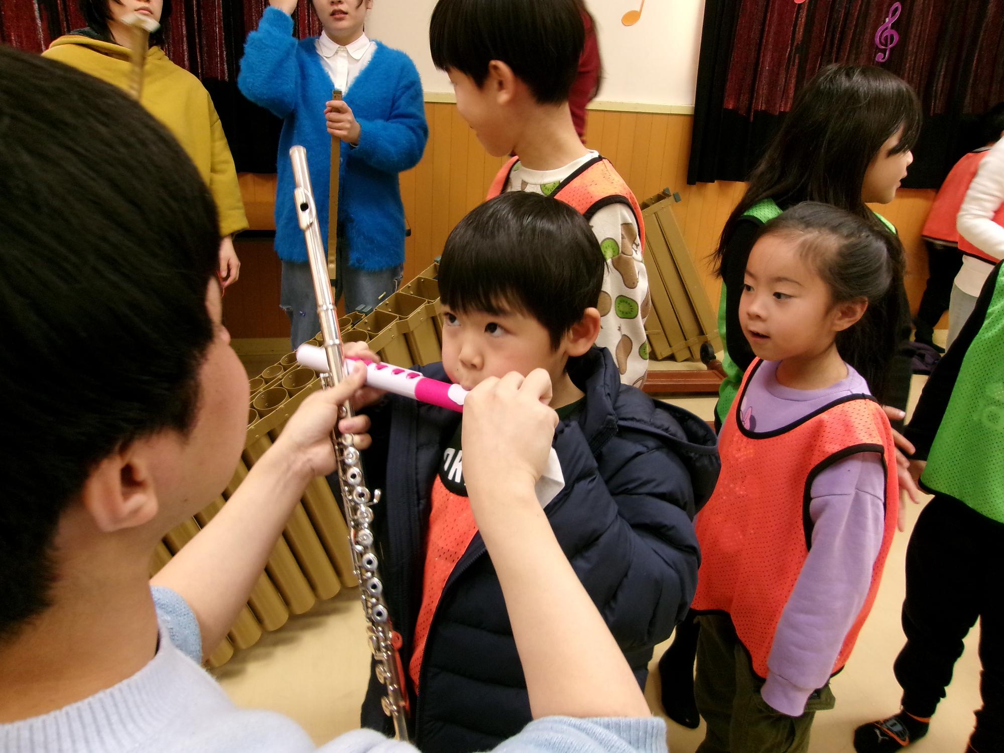 子どもたちが楽器を体験させてもらっている写真