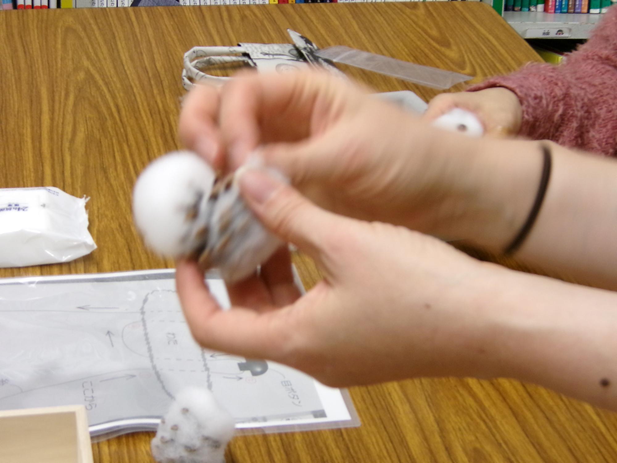 松ぼっくりに綿を付けている写真