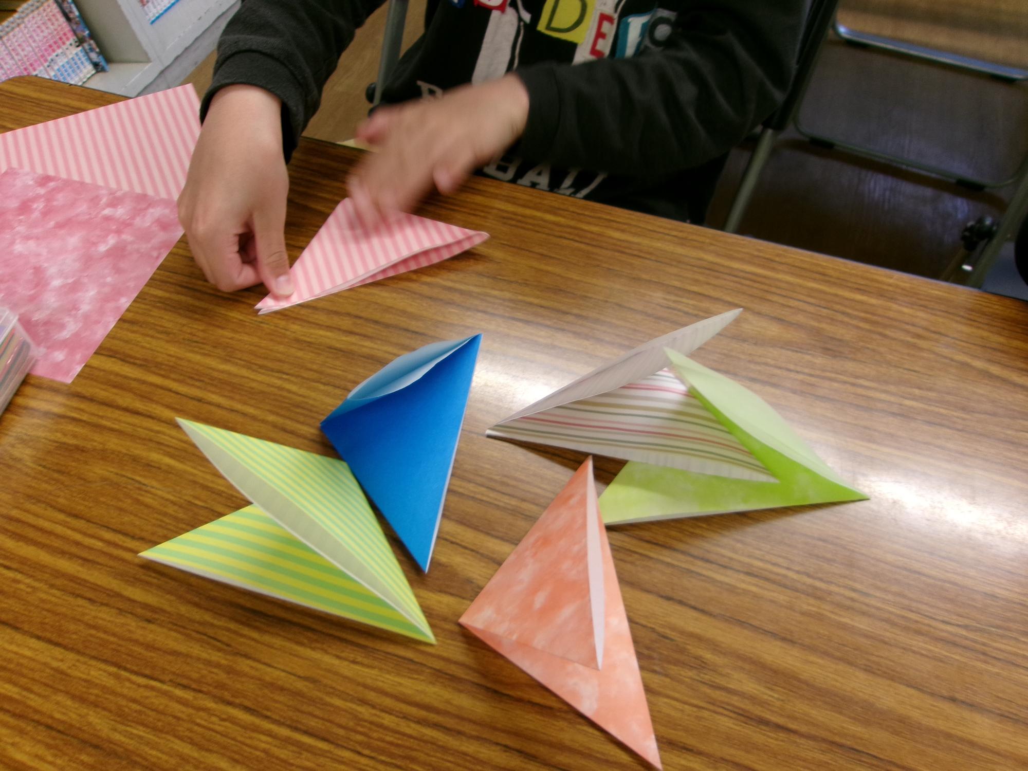 男の子が6枚目の三角を折っている写真