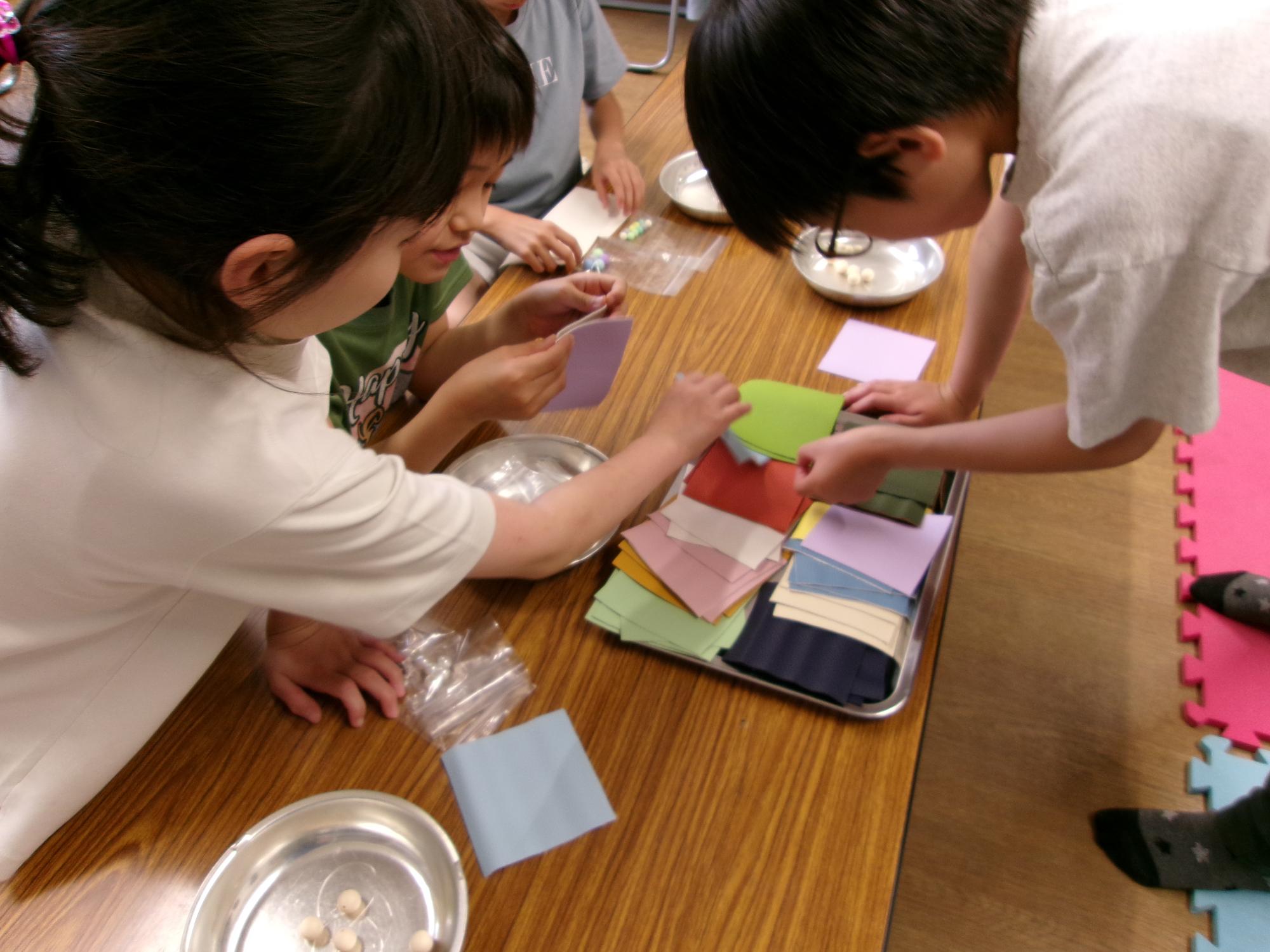 子どもたちが工作の材料の色を選んでいる写真