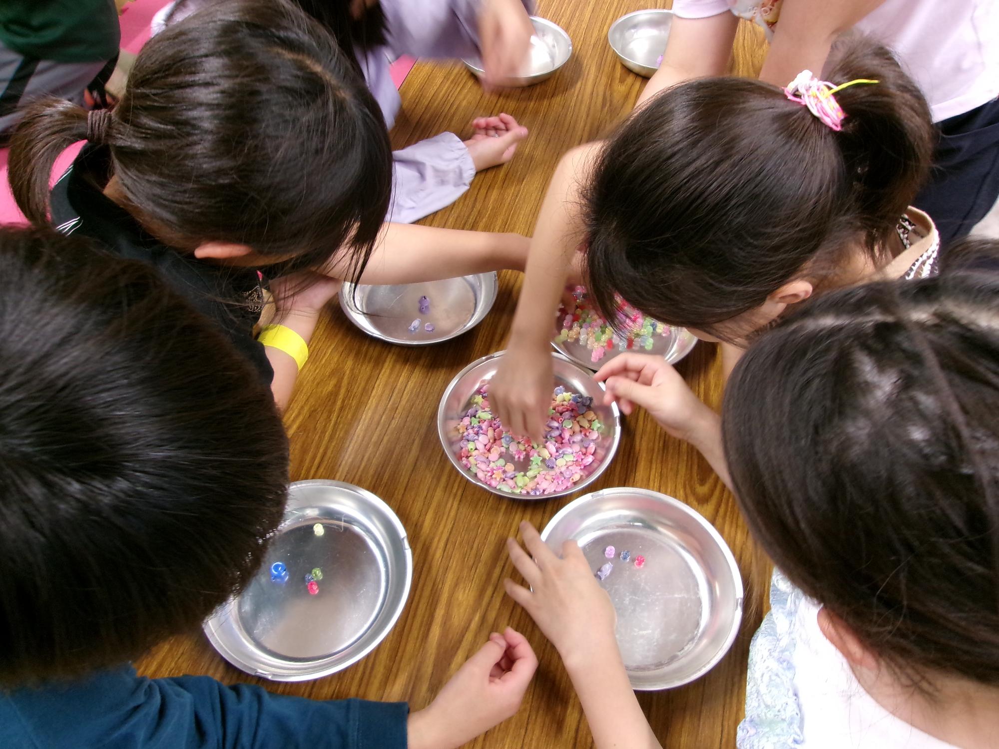 子どもたちがビーズを選んでいる写真