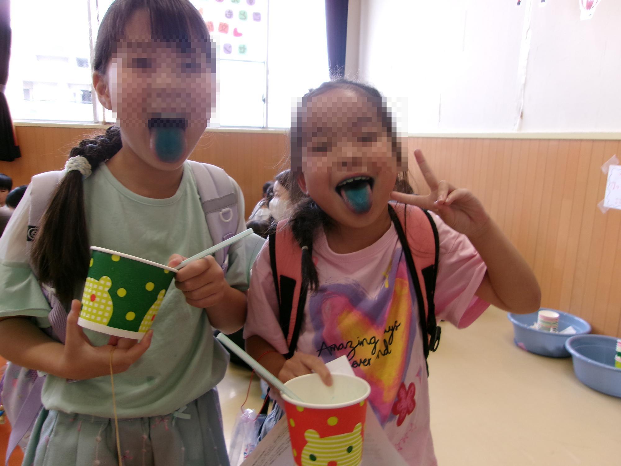 かき氷を食べて色がついた舌を見せている写真