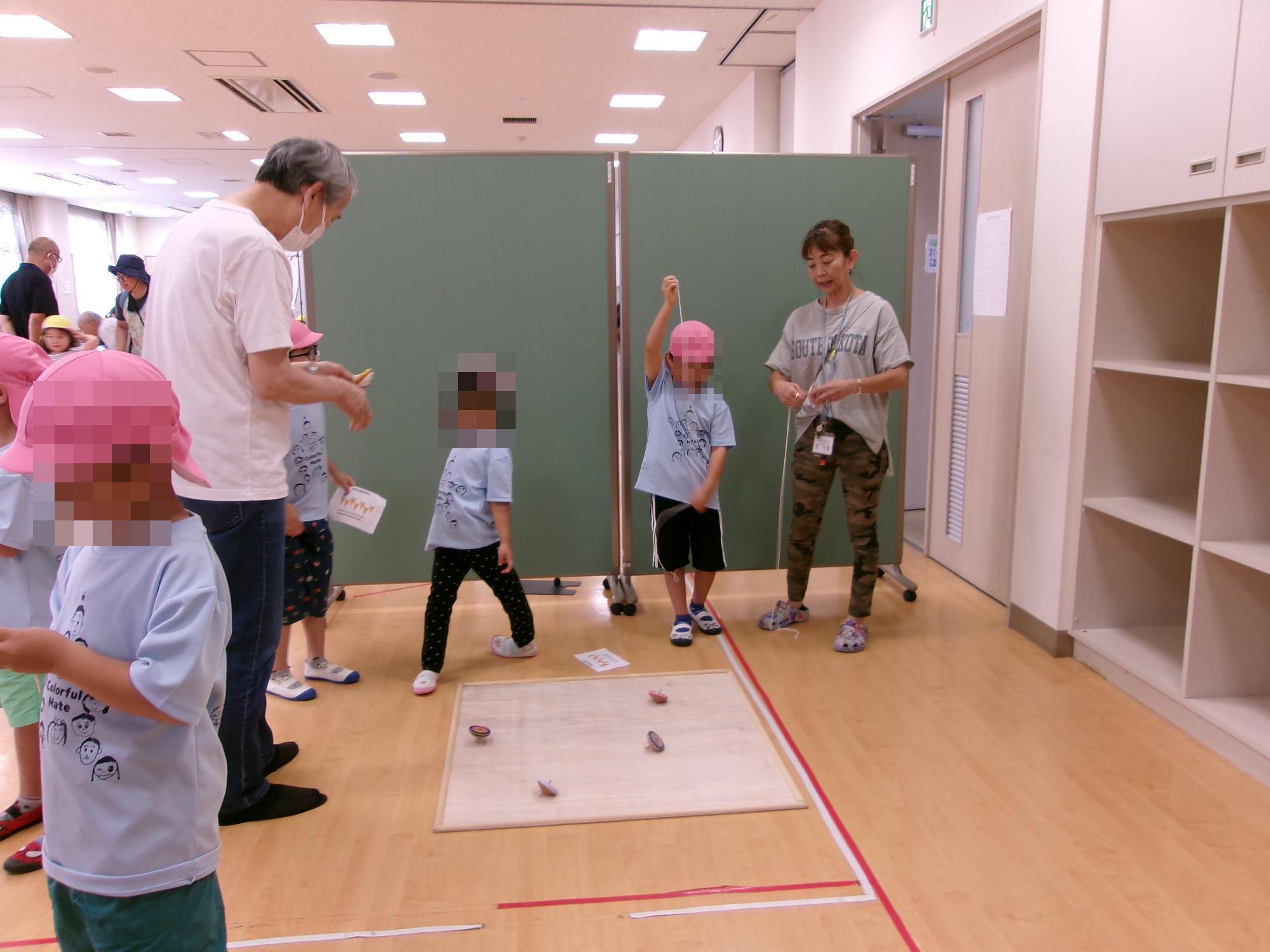 コマを参加者に教えている様子の写真
