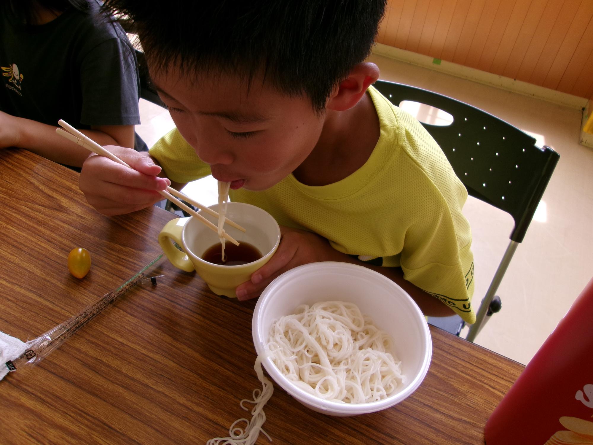 男の子がそうめんを食べている写真