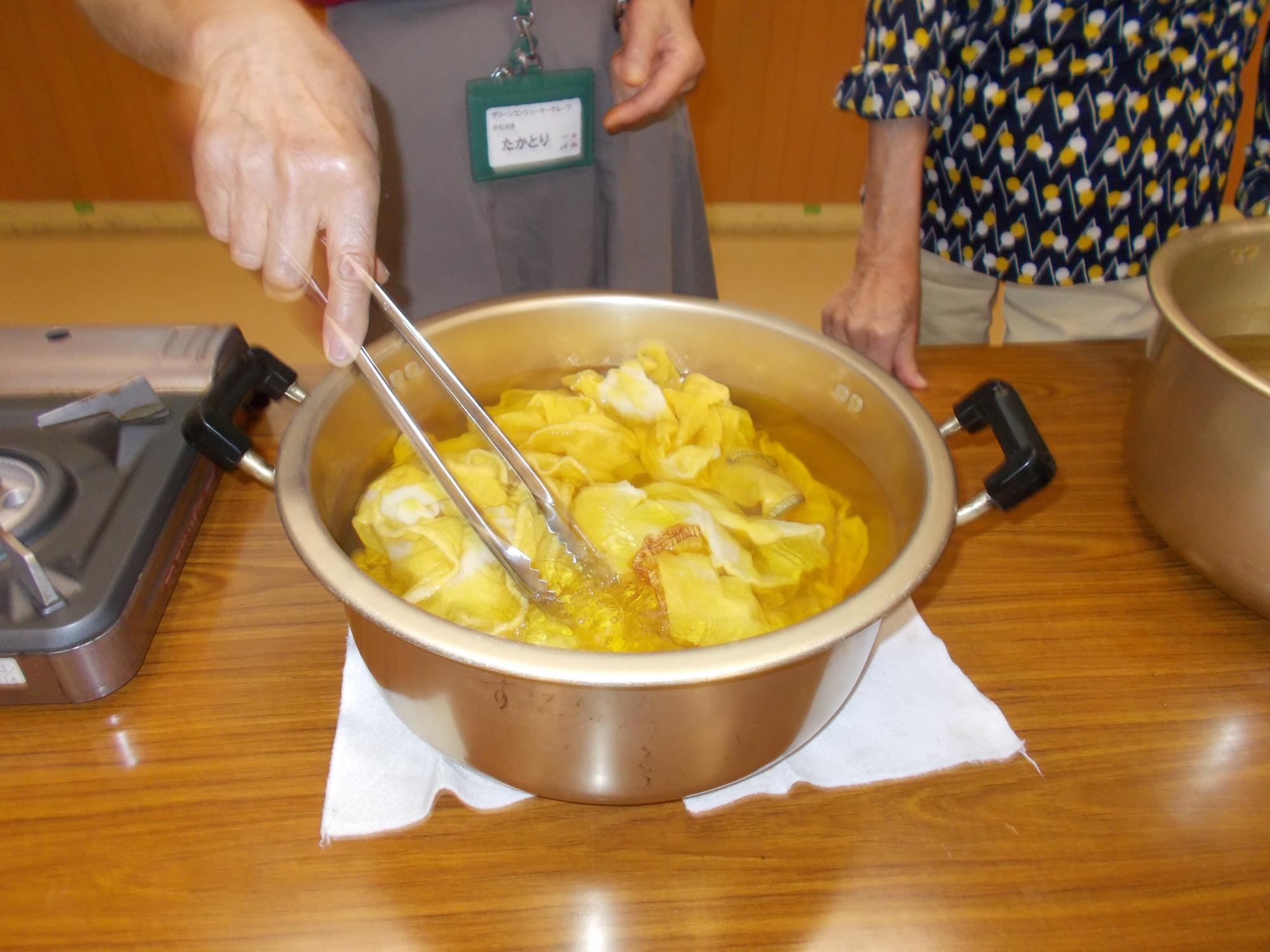 みょうばん入りのお湯にふきんを戻して色を定着させている写真