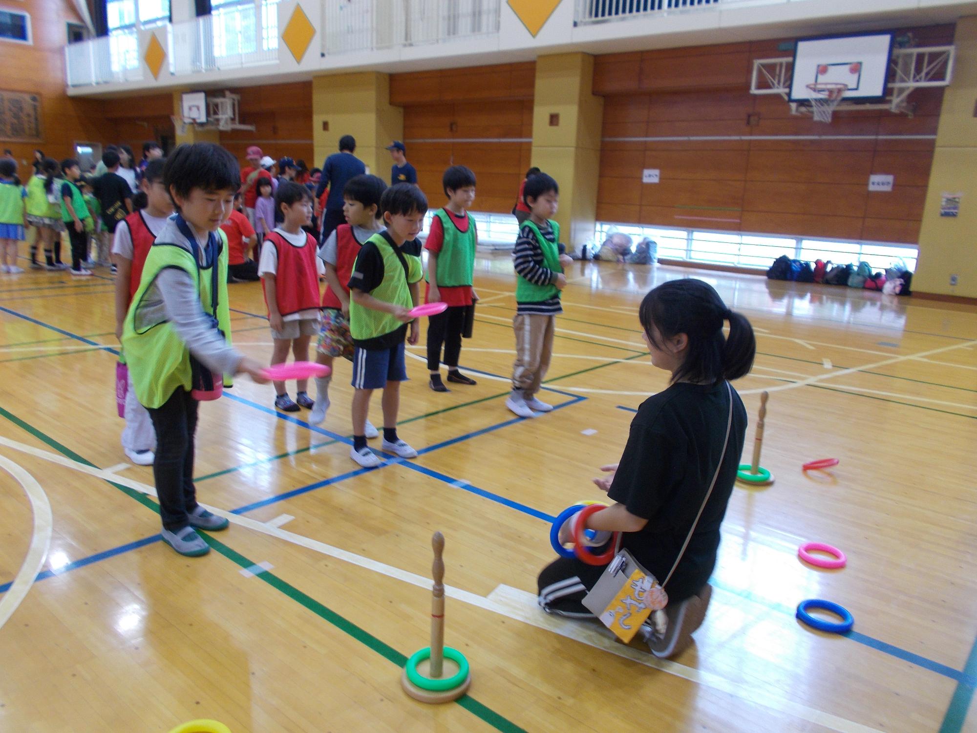 子どもたちが輪投げをやっている写真
