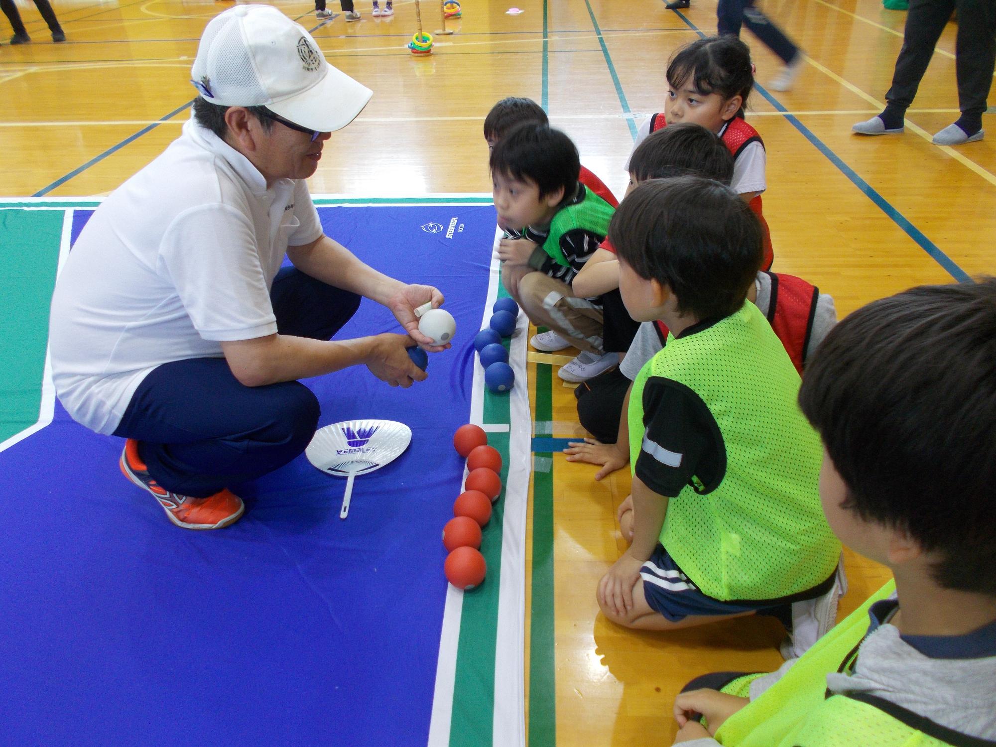 子どもたちがボッチャの説明を受けている写真