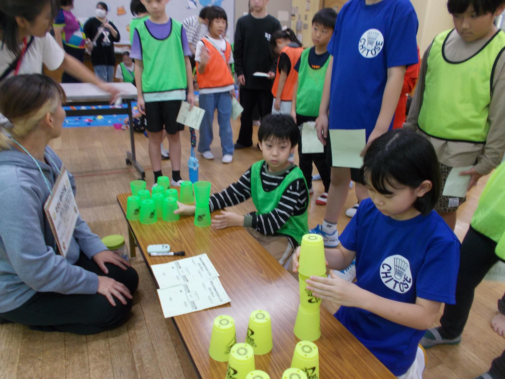 子どもたちがカップを積んでいる写真
