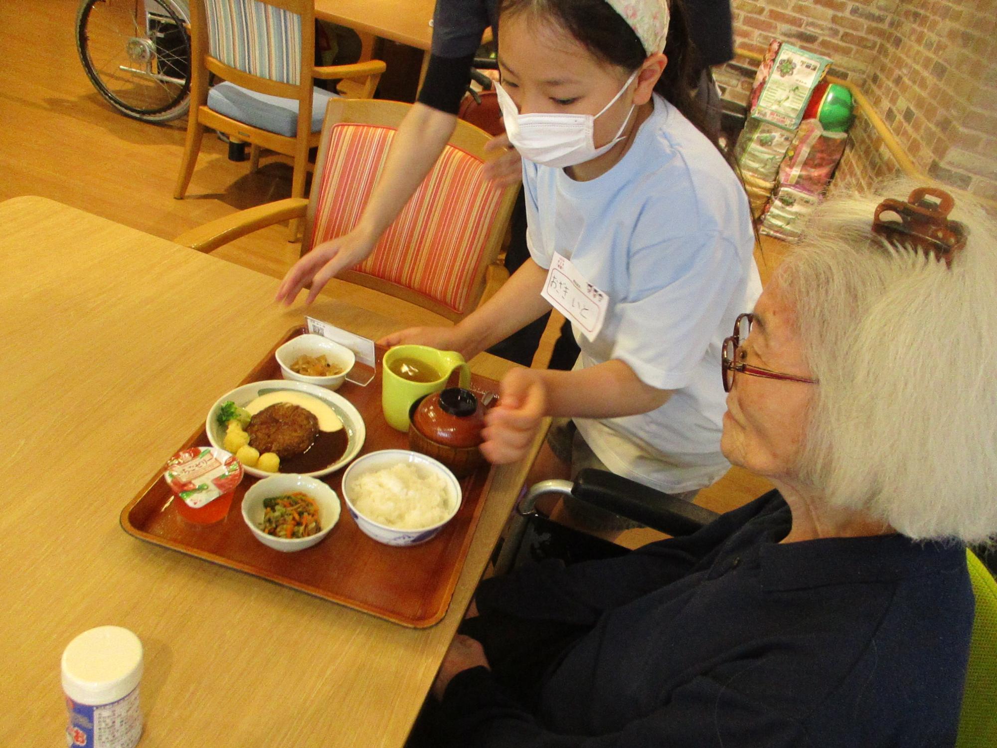 女の子が配膳の手伝いをしている写真