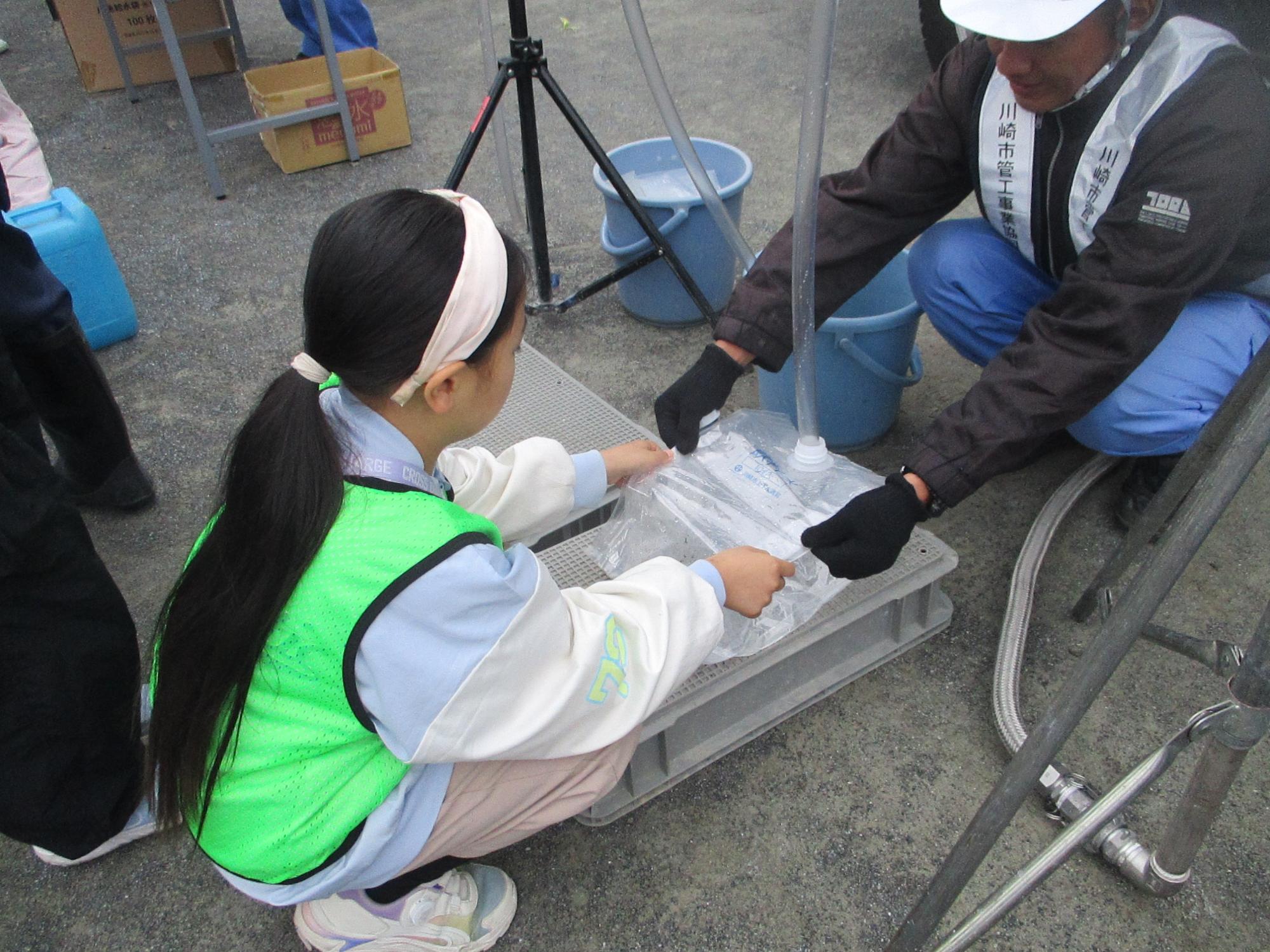女の子が給水体験をしている写真