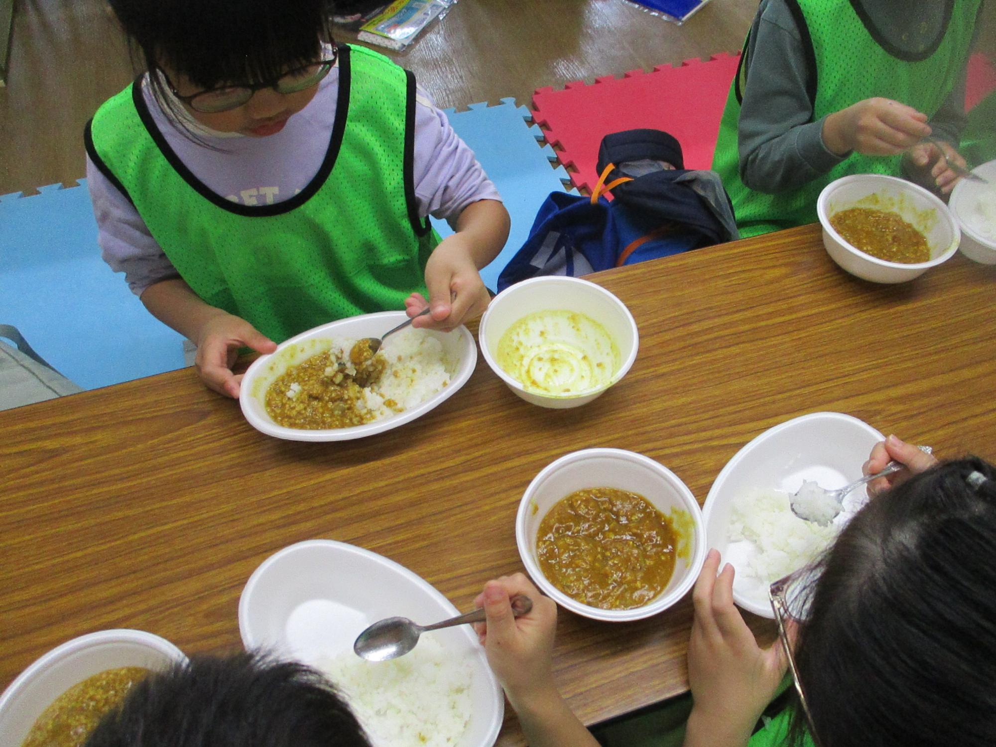 子どもたちがカレーを食べている写真