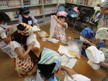 子どもたちが氷の入った袋にタオルを巻いている写真