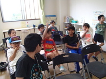 広い部屋に集まった子どもたちが、これから行うゲームについて話し合いをしている写真