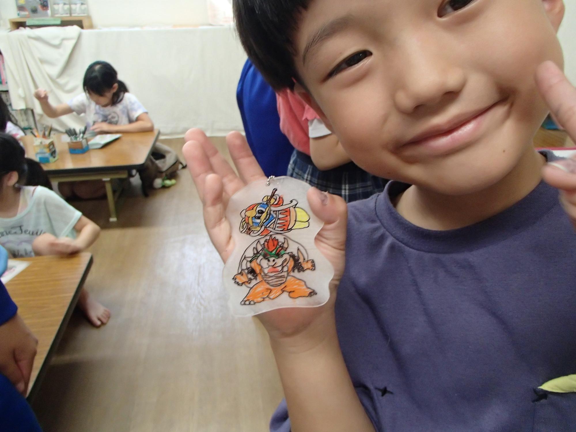 完成したプラバンと共に笑顔で写る男の子の写真