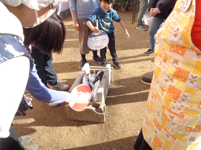 炭火を仰いでいる様子